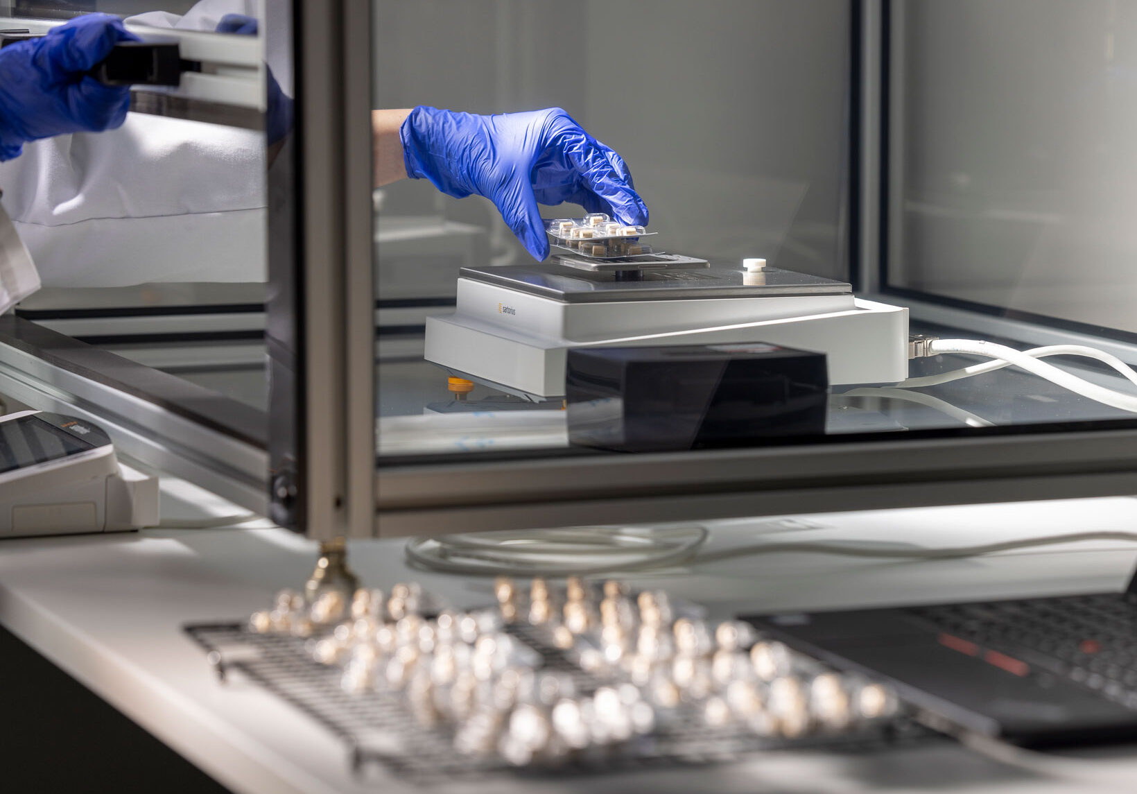 Gloved hand holding package performing moisture vapor transmission rate